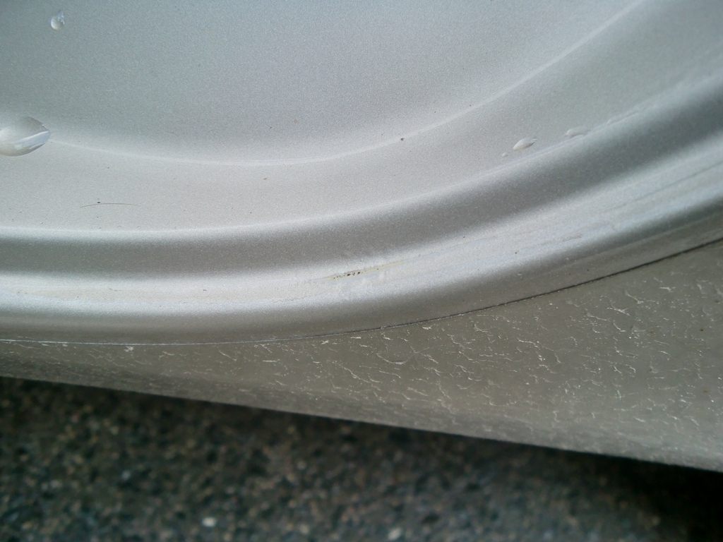 Fahrerseite, Hintertür Ecke rechts unten, da rostet es aktuell noch nicht, jedoch kommt auch schon das schwarze durch